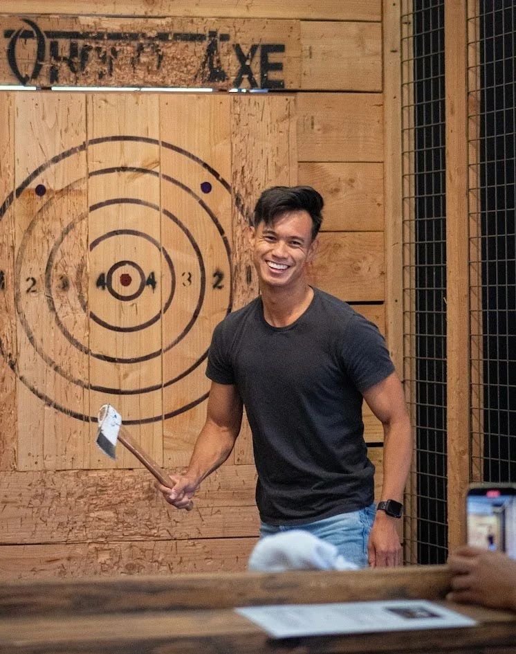 Guest smiling as he pulls his axe from a Whoop Axe bullseye