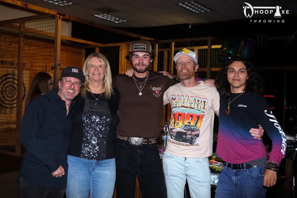 A group celebrating together beside the indoor axe lanes